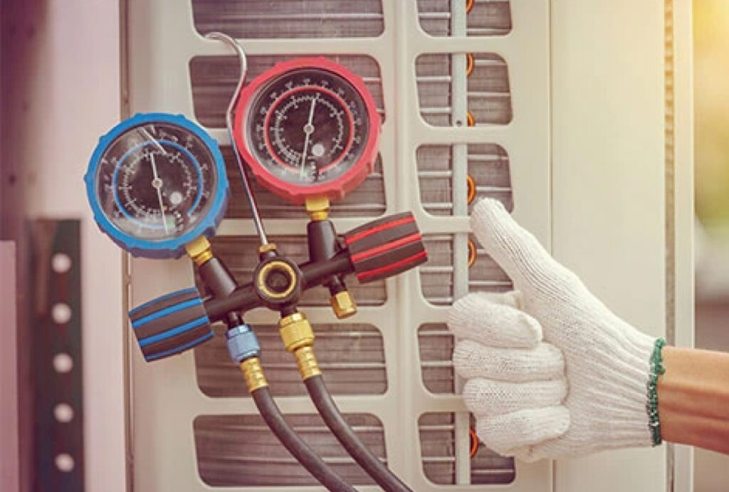 A gloved hand showing a thumbs up beside air conditioning repair equipment