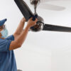 A man installing a ceiling fan