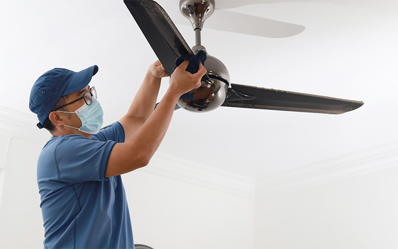 A man installing a ceiling fan