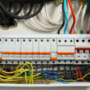 Electrical panelboard with wires and circuit breakers.
