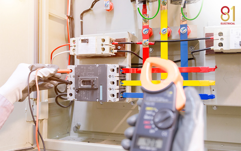 Electrician checking electrical panel for rewiring in Singapore.