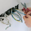 Electrician cutting wires for electrical rewiring in Singapore.