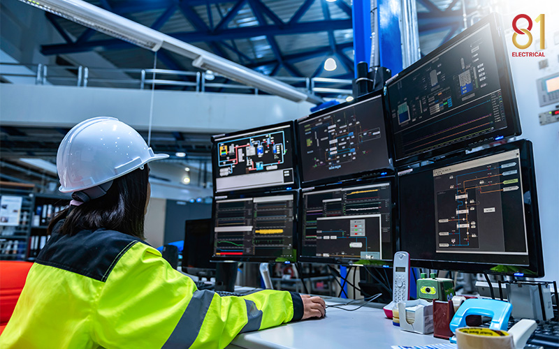 Engineer monitoring automation control systems on multiple screens.