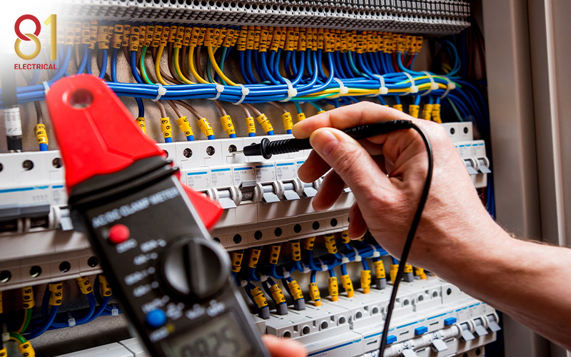Electrician testing a circuit breaker with a multimeter.