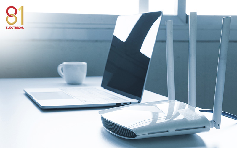 A Wi-Fi router next to a laptop.