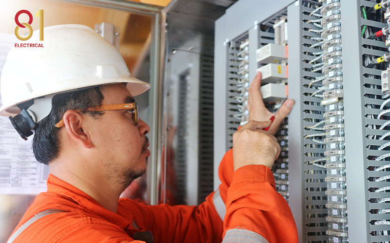 Electrician working on three-phase electrical connections.