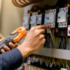 Electrician measuring voltage in an electrical box.
