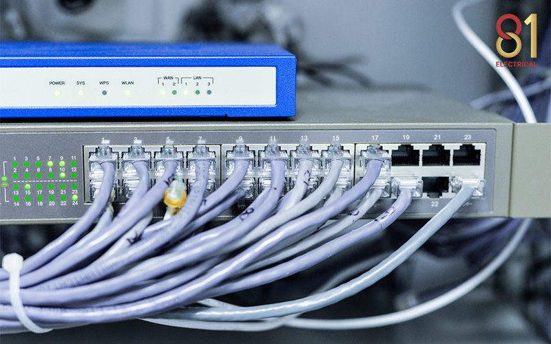 Network switch with connected Ethernet cables and router above