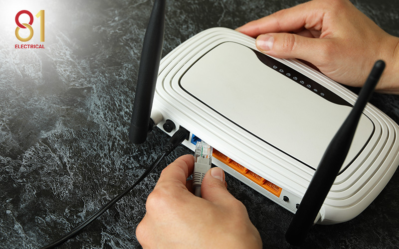 Person connecting a LAN cable to a home router.