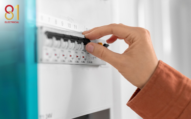 Person resetting a fuse box in a home.