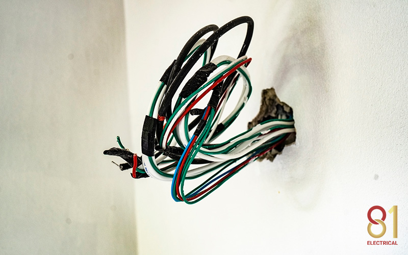 Exposed wires protruding from a wall