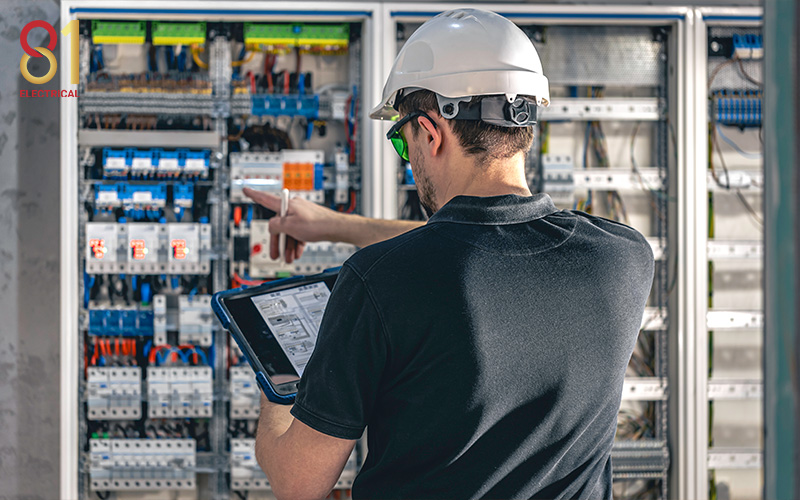 Electrician inspecting an electrical panel for circuit planning.