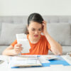 Woman stressed while looking at a high electricity bill.