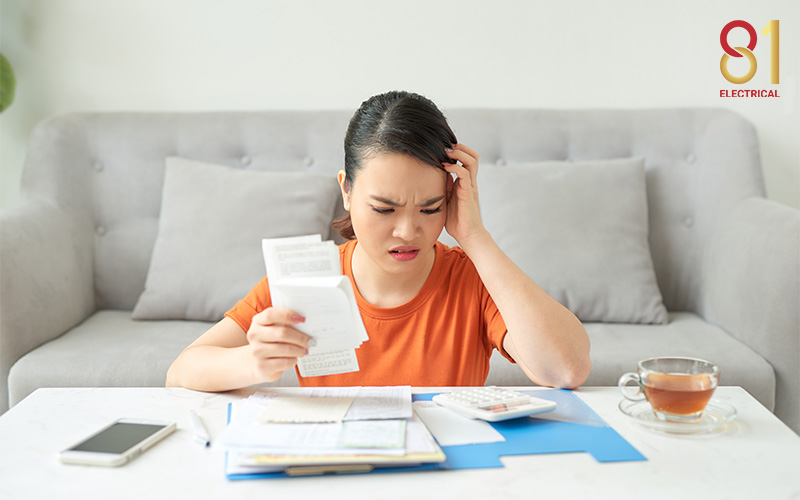 Woman stressed while looking at a high electricity bill.